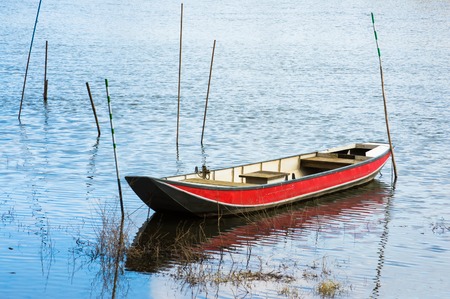 Red boat on a tranquil surface of a riverの写真素材