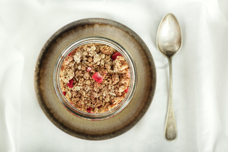 Granola in brown bowl and spoon, view from above.の写真素材