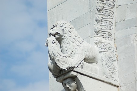 Lion statue on background of blue sky detail from the facade of the Cathedral of St Martin in Lucca Tuscan Italyの写真素材
