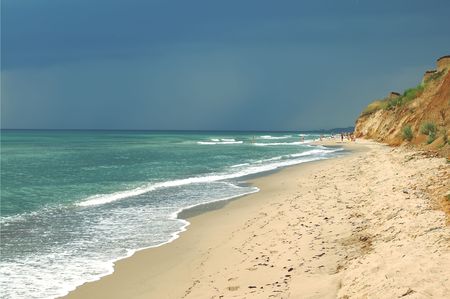 On horizon a storm front is approached, people abandon a beach hastilyの写真素材