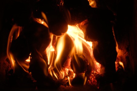 Flames of fire from the wood in a brick fireplaceの写真素材