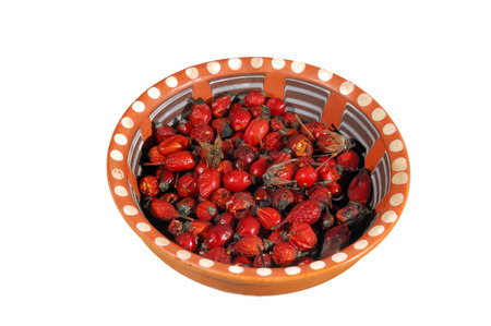 Dried rose hips in a clay bowlの写真素材
