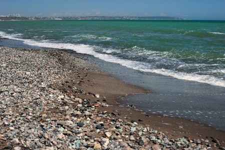 Surf line on the sea coast with small pebbles in the foregroundの写真素材