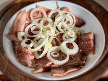salted herring with white onion on a white plateの写真素材