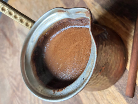 Aromatic Turkish coffee in a copper cezve with rich foam.の写真素材
