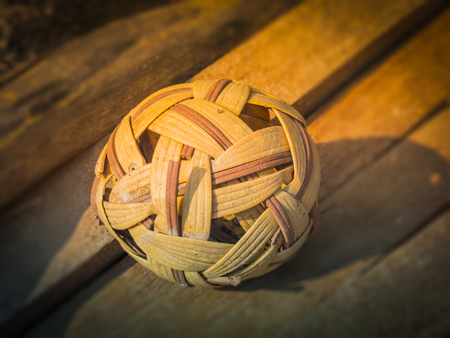 The old rattan ball (sepak takraw) on woodの写真素材