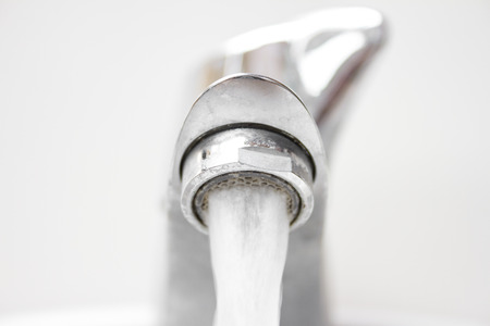 Front view of modern style opened dirty faucet closeup view with small depth of field