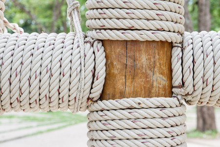 Closeup view of rope tied around wooden pillarの写真素材