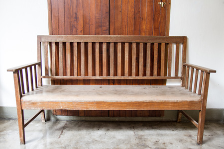 Front view of old wood bench in front of doorの写真素材