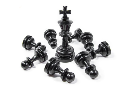 Chess king against chess pawns isolated on white background, small depth of fieldの写真素材