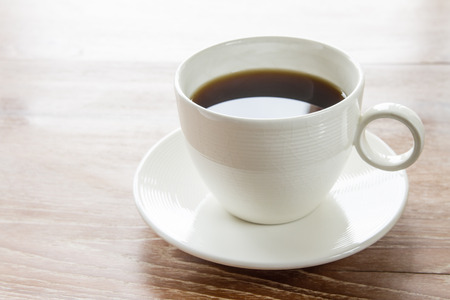 White cup of coffee on wooden tableの写真素材