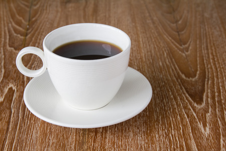 White cup of coffee on wooden tableの写真素材
