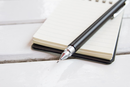 blank notebook and pencil on white tableの写真素材