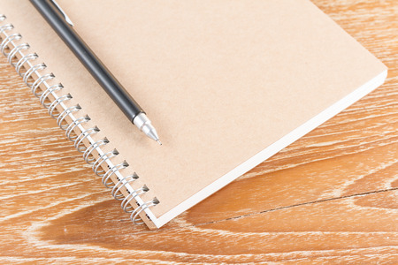 notebook and pencil on wooden background