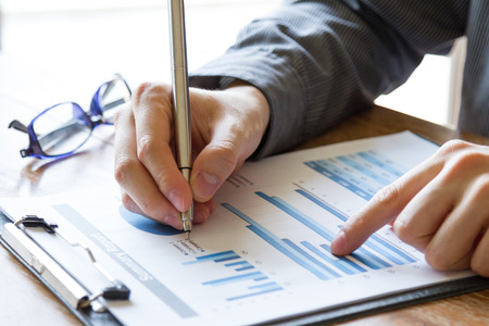 business people analyzing graph and chart document on office deskの写真素材