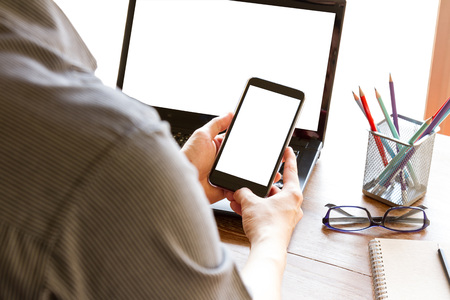 business man using mobile phone with blank white screen on office deskの写真素材