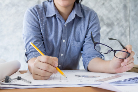 architect working and sketching architectural drawing plan on table in officeの写真素材