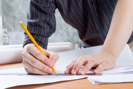 architect working and sketching architectural drawing plan on table in office