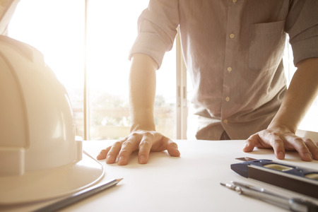 engineer drawing and planning architectural project with engineering tools on desk in officeの写真素材
