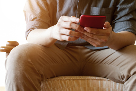 business man using mobile phone on sofaの写真素材