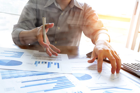 business people analyzing graph and chart document on office deskの写真素材