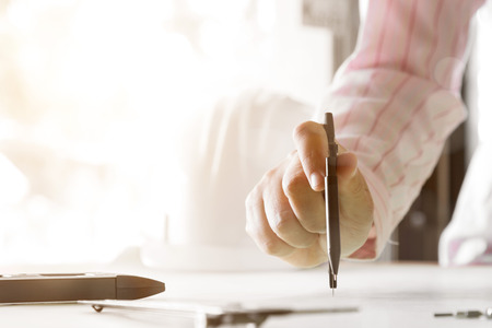 architect working and sketching architectural drawing plan on table in office