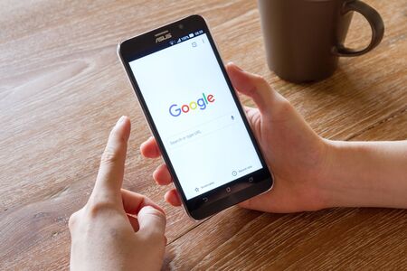 CHIANG MAI, THAILAND - APR 26, 2016: man hand holding screenshot of Google Chrome application...