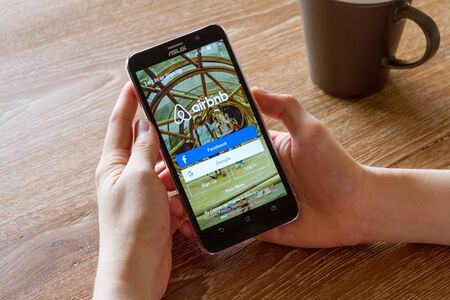 CHIANG MAI, THAILAND - APR 26, 2016: man hand holding screen shot of Airbnb application showing on...