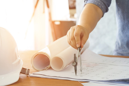 architect working and sketching architectural drawing plan on table in office
