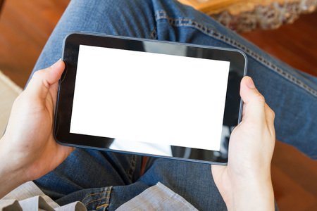 man using tablet computer with blank white screen in living room