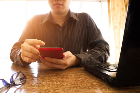 business man using mobile phone on office deskの写真素材