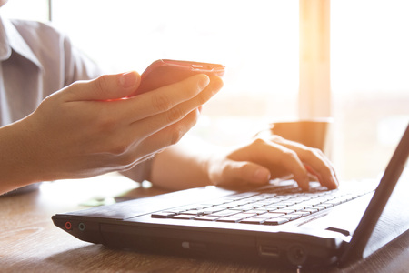man holding credit card and using mobile phone and laptop computer for online shopping