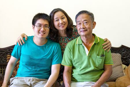 portrait of happy asian family sitting on couch