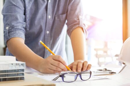 architect working and sketching architectural drawing plan on table in officeの写真素材