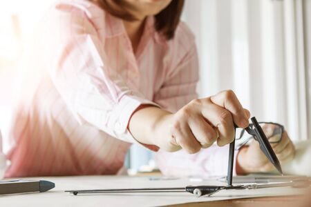 architect working and sketching architectural drawing plan on table in officeの写真素材