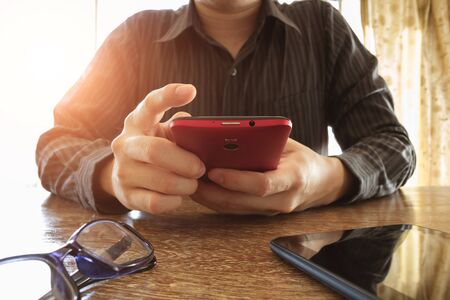 businessman using mobile phone on office deskの写真素材