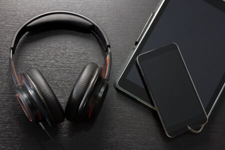 black headphones and digital tablet computer on black table or background with copy space - musical conceptの写真素材