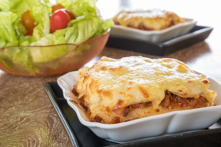 italian style minced beef bolognese sauce lasagna on wooden tableの写真素材