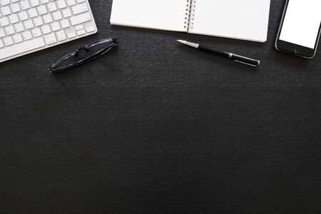 black office wooden desk table with computer, tablet, mobile phone, and office supplies - table top...