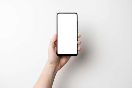 hand holding black mobile phone with white screen isolated on white background - clipping path includedの写真素材