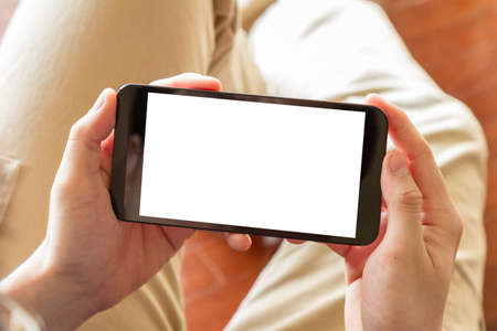 man using mobile phone with blank screen indoor, close up