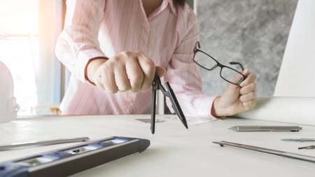 architect working and sketching architectural drawing plan on table in officeの写真素材