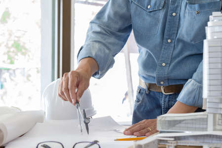 architect working and sketching architectural drawing plan on table in officeの写真素材