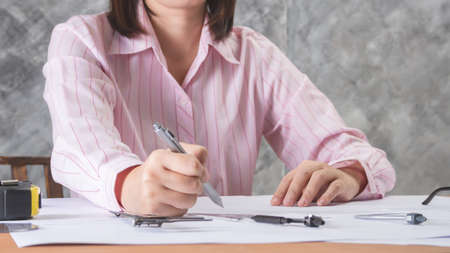 architect working and sketching architectural drawing plan on table in officeの写真素材