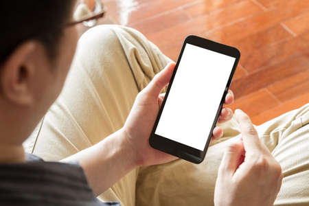 man using mobile phone with blank screen indoor, close upの写真素材