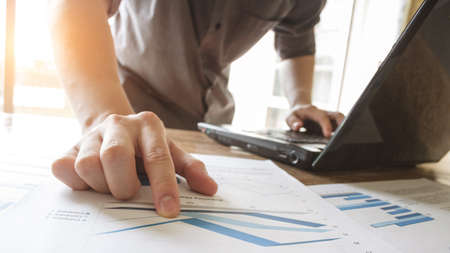 business man working analyzing on graph chart information diagram document on office desk as concept
