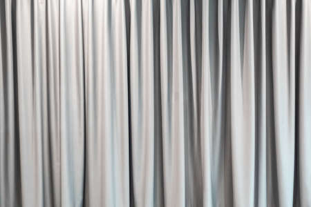 Light gray curtain background wallpaper. Abstract white fabric texture for decoration. Luxury vertical clean and smooth cloth backdrop. Modern home interior.の写真素材