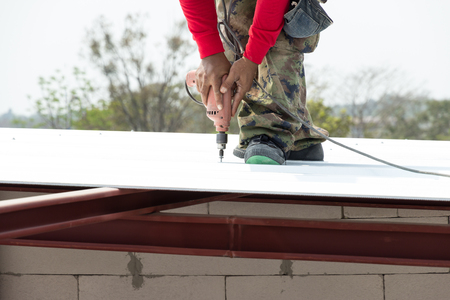 Man working on roof Metal cheese in site constructionの写真素材