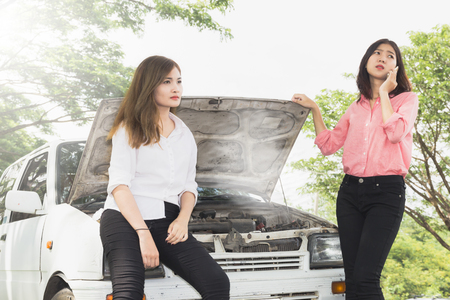 Woman with broken car on the road waiting for help.の写真素材