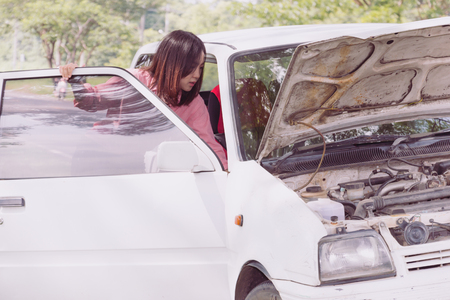 Woman with broken car on the road waiting for help.の写真素材